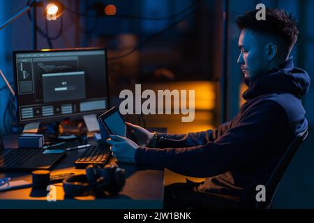hacker using tablet pc computer for cyber attack Stock Photo