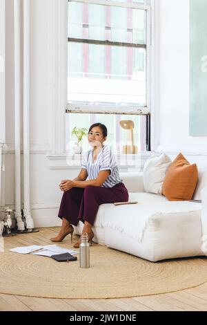 Portrait of confident young businesswoman sitting on sofa Stock Photo