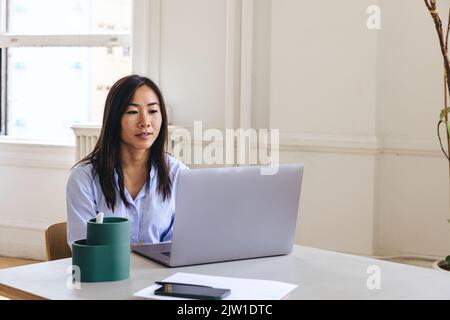 Female entrepreneur using laptop on desk in creative office Stock Photo