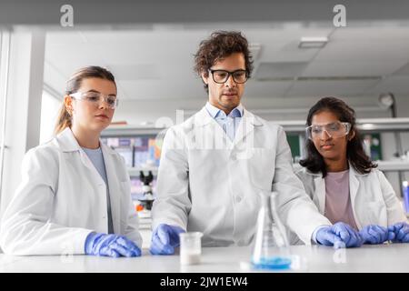 scientists with chemicals working in laboratory Stock Photo