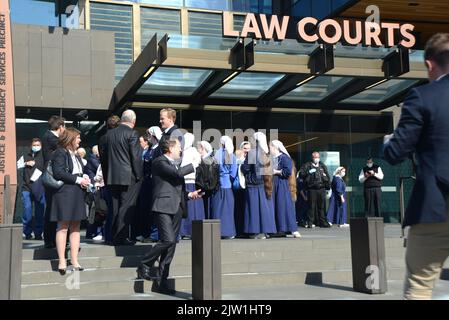 CHRISTCHURCH, NEW ZEALAND, AUGUST 29, 2022: Members of the Gloriavale Christian Community gather outside the Justice Precinct building in Christchurch where a hearing was underway over the employment status of women in the community. Stock Photo