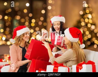 happy women in santa hats with christmas presents Stock Photo