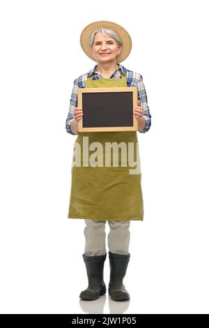 happy senior woman in garden apron with chalkboard Stock Photo
