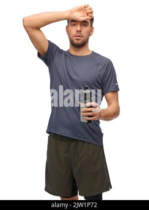tired man in sports clothes with bottle Stock Photo