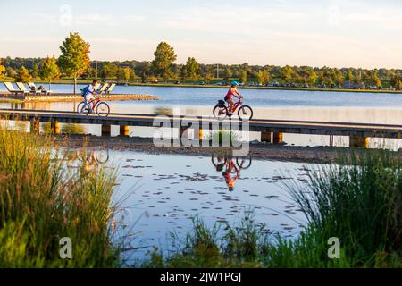 A group of bicyclists rides along Patriot Lake in Shelby Farms Park, Memphis, TN. On Aug. 31, 2022. Stock Photo