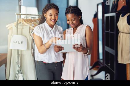 Deciding on new stock to order online. young business partners working on a digital tablet together. Stock Photo