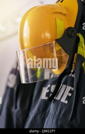 Fire fighting gear. firemens clothing hanging from a wall. Stock Photo