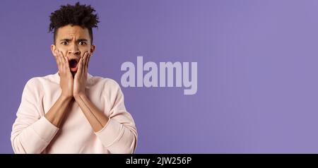 Oh gosh thats terrible. Portrait of shocked, speechless and worried young man express compassion finding out friend got in trouble, gasping open mouth Stock Photo