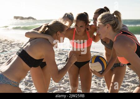 Female volleyball players discussing on the beach Stock Photo