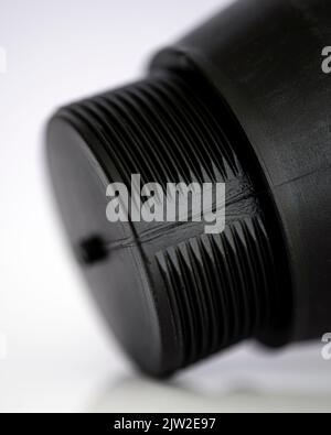 The end of a black plastic cylinder has a male thread, on a white background Stock Photo