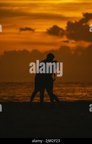 Silhouette of a couple kissing against a sunset sky Stock Photo - Alamy