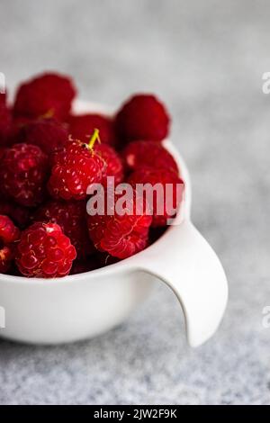 From above close up of ripe raspberries in the bowl Stock Photo