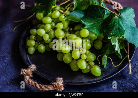 From above of heap of fresh ripe grapes placed on dark background Stock Photo