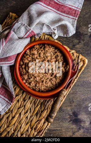 Famous Georgian Lobio with walnuts dish served in ceramic bowl on wooden table Stock Photo