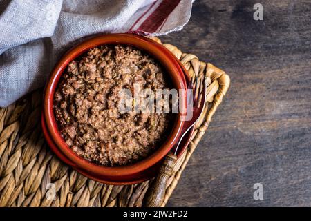 Famous Georgian Lobio with walnuts dish served in ceramic bowl on wooden table Stock Photo