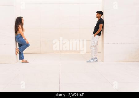 Full length of young couple looking at each other while standing face to face Stock Photo