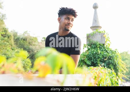 Confident young man looking away while standing against sky Stock Photo