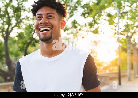 Cheerful young man looking away while standing at park Stock Photo