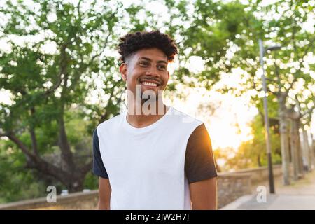 Cheerful young man looking away while standing at park Stock Photo