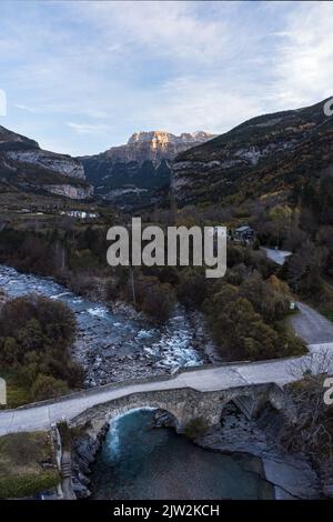 Amazing aerial view of bridge under wild river and curvy roads in scenic mountainous valley in Torla town located in province of Huesca Stock Photo