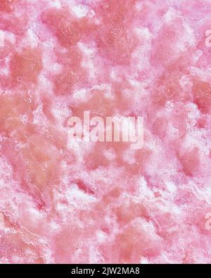 Closeup surface of uneven natural quartz stone of pink color forming textured background Stock Photo