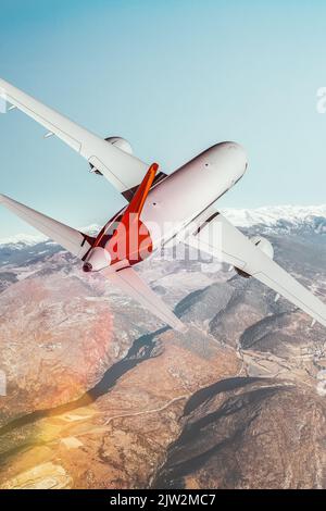 View from behind of a commercial plane flying over the mountains. Blend of 3D and raster images Stock Photo