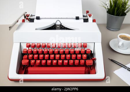 Red and white typewriter with blank paper on desk. Creative writing copywriter concept Stock Photo