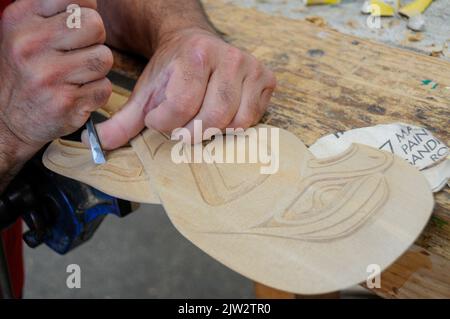 A wood carver is working on a Maori carving at the Carving school at Te Puia Maori arts and crafts Institute near Rotorua on North Island in New Zealand. Stock Photo