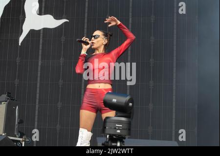 Maeve singing wearing a red top and shorts Stock Photo