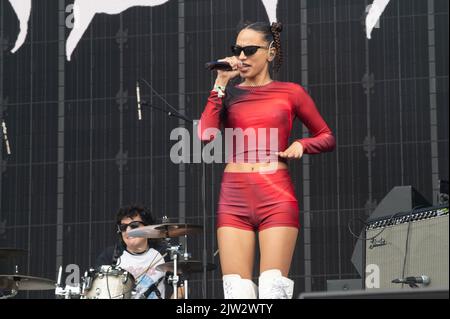 Maeve singing wearing a red top and shorts Stock Photo