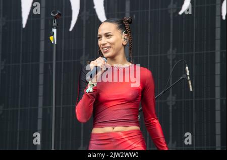 Maeve singing wearing a red top and shorts Stock Photo