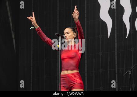 Maeve singing wearing a red top and shorts Stock Photo