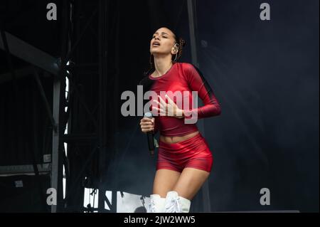 Maeve singing wearing a red top and shorts Stock Photo