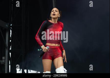 Maeve singing wearing a red top and shorts Stock Photo