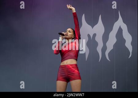 Maeve singing wearing a red top and shorts Stock Photo