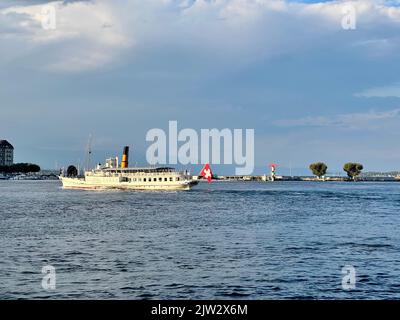 Swiss excursion boat sailing on Lake Geneva with swiss flag. This steamboat crosses the lake with tourists. Boat tour from Geneva Stock Photo