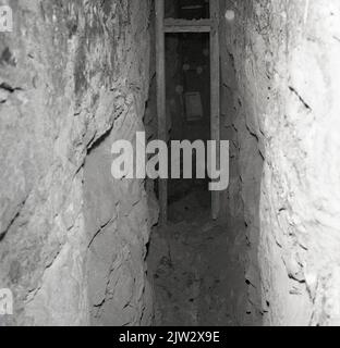 1960s, historical, inside a disused mine shaft at the old coal-mining village of Townshill, Fife showing narrow tunnel and thin wooden wall strut. Stock Photo