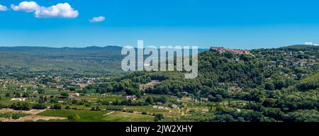 Distant panoramic view of the village of Le Castellet, France, built on top of a hill overlooking the surrounding countryside and vineyards of Bandol Stock Photo