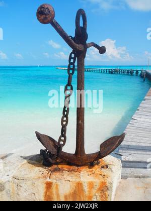 Rusty anchor on the coast in Mexico Stock Photo