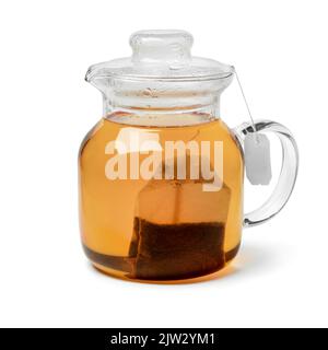 Glass tea pot with hot tea and a tea bag isolated on white background Stock Photo