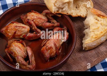 Rustic dinner. Roasted quail meat and white bread Stock Photo
