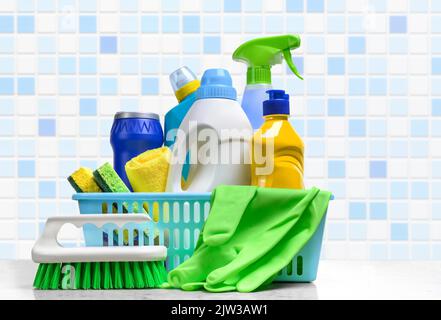 Cleaning supplies in plastic box on white table in the bathroom Stock Photo