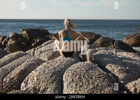 Female volleyball player meditates on the beach Stock Photo