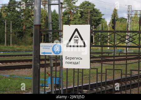 A sign beware of the train seen at the railway crossing in the Leningrad region. Stock Photo