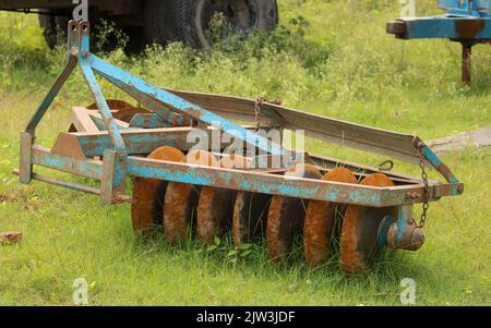 The disc harrow is an agricultural tool used for cultivating soil. Stock Photo