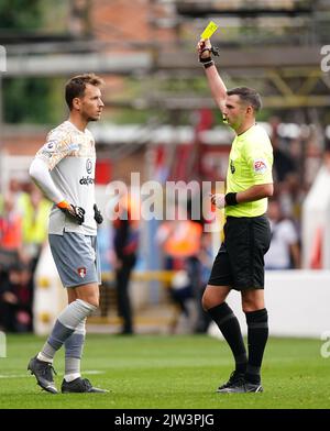 Referee Michael Oliver shows AFC Bournemouth goalkeeper Murara Neto a yellow card during the Premier League match at The City Ground, Nottingham. Picture date: Saturday September 3, 2022. Stock Photo
