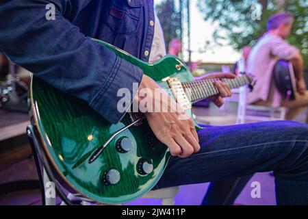 closeup of man playing guitar on concert Stock Photo