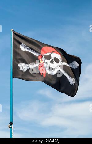 Pirate flag against sky Stock Photo