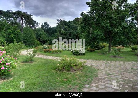 Paris, France - May 29, 2022: View of Chateau de Bagatelle across wild garden with flowers, trees and tourists Stock Photo