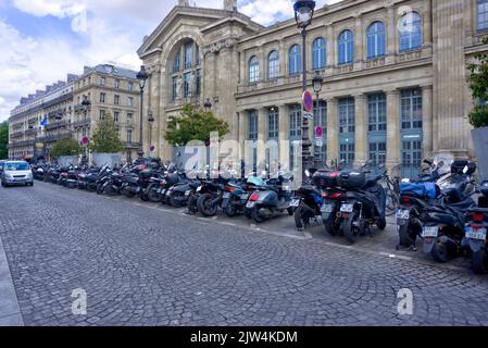 Paris, France - May 30, 2022: Exterior of Gare du Nord rail station with large row of parked motorcycles and scooters in foreground Stock Photo